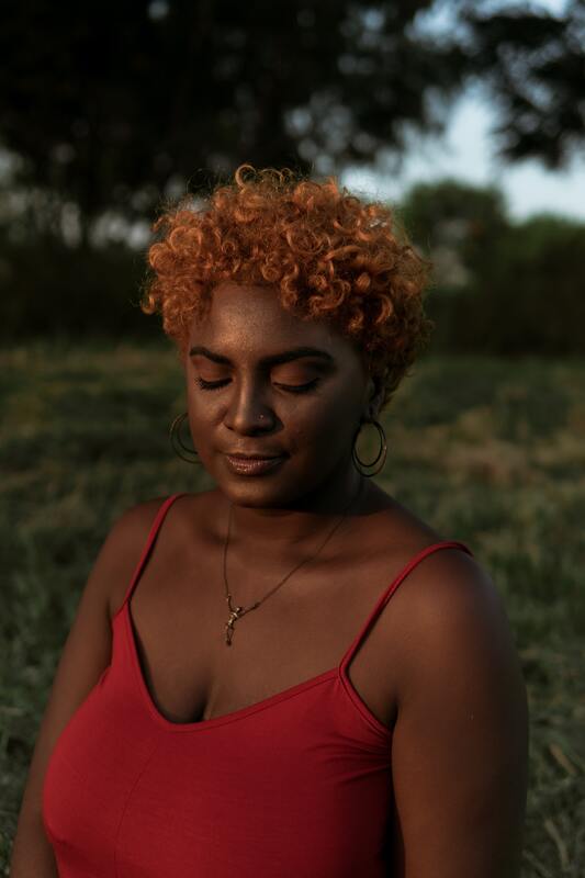 Young black woman with her eyes closed and a serene look on her face. This illustrates that Sacred Circle Holistic Healing offers online therapy in Kansas and incorporates mindfulness practices into therapy.