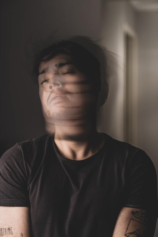 Young man crossing his arms and shaking his head back and forth with this eyes shut. This illustrates that Sacred Circle Holistic Healing offers online therapy in Kansas to help young adults learn to cope with their emotions.