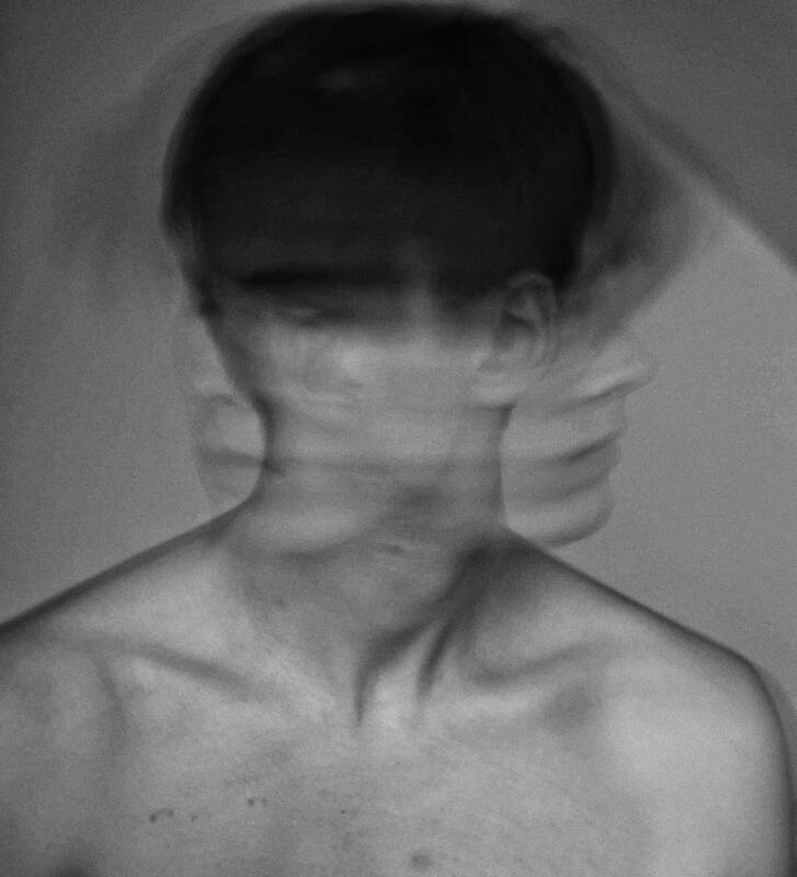 Black and white photo of person shaking their head violently. This represents that grief leads to many, often conflicting, feelings. Maggie Jones Boyle is a licensed professional therapist in Lawrence, Kansas.