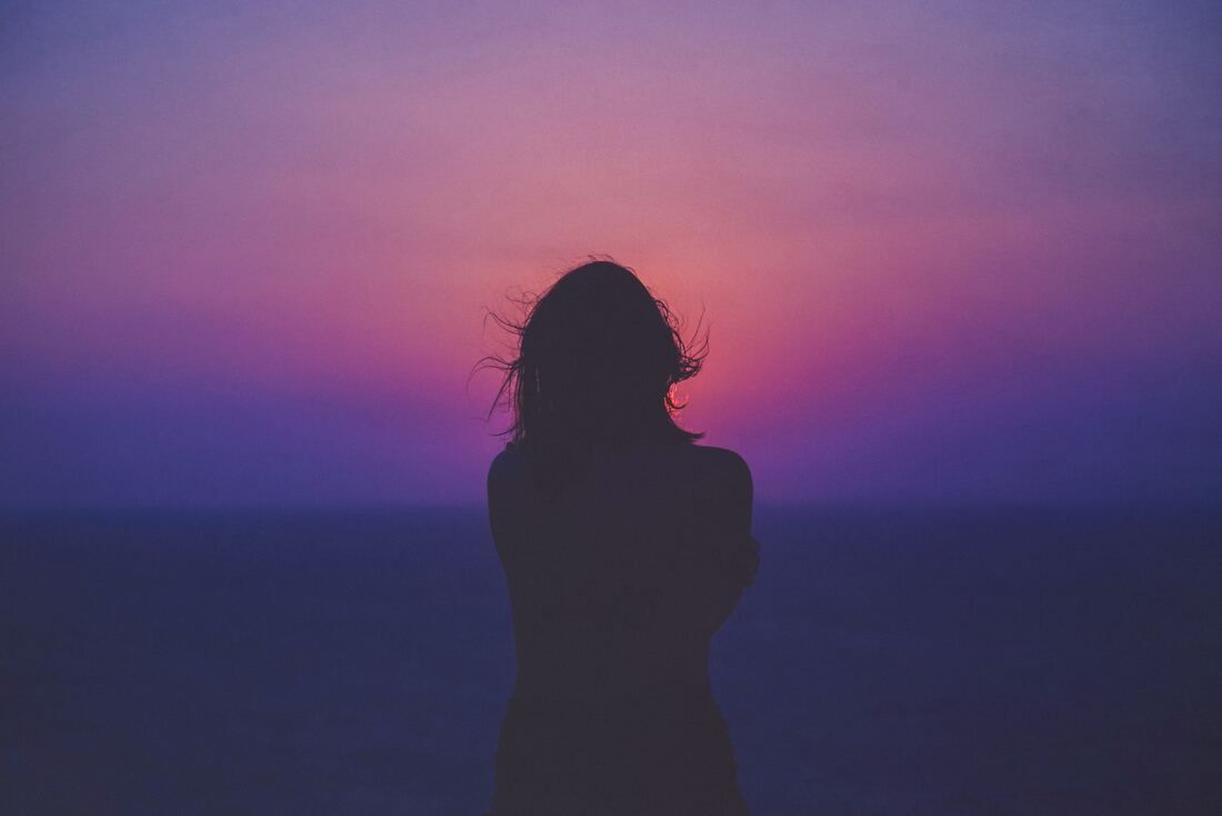 silhouette of woman watching sunset. This illustrates that Sacred Circle Holistic Healing offers online therapy in Kansas for young adults learning how to navigate relationships.
