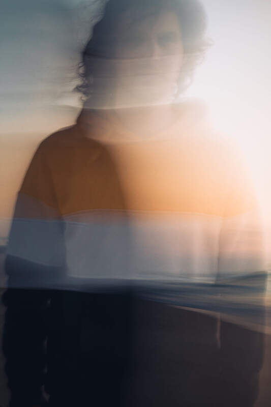 A blurred portrait of a young man staring into the camera. This represents HSPs who often experience stron emotional reactivity, or emotional overwhelm.