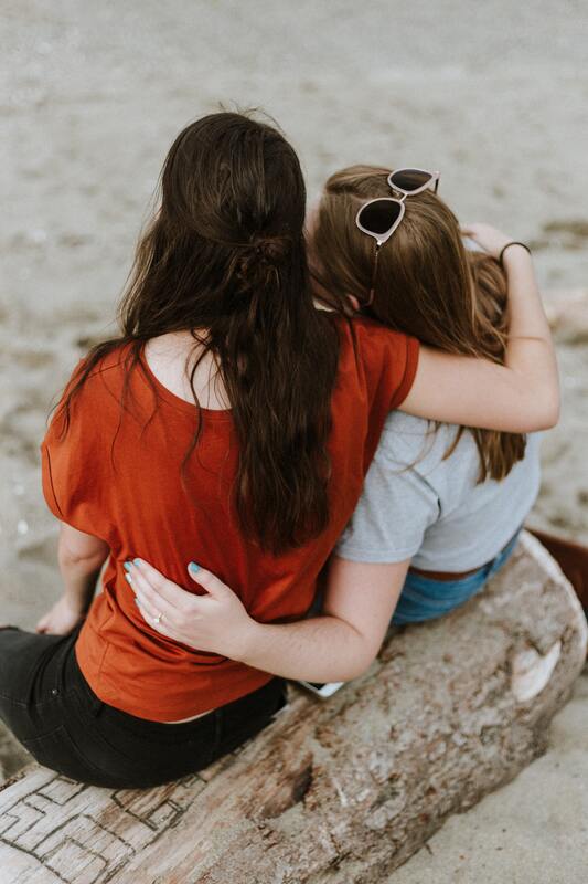Two women with their arms around each other's shoulders. This illustrates and healthy boundaries promotes relational intimacy. Boundary work is a service offered by Sacred Circle Holistic Healing through online therapy.