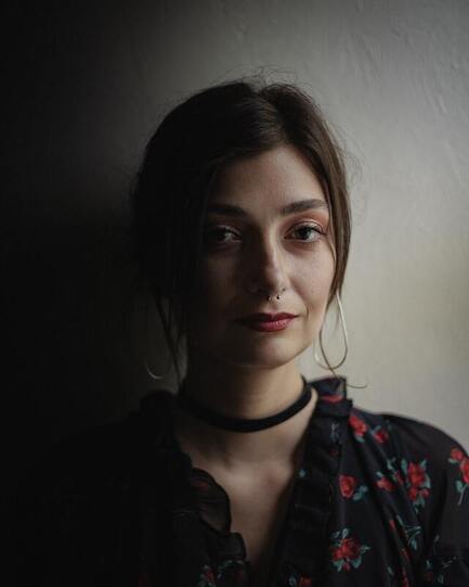 Portrait of a young women with a nose piercing not smiling at the camera. This illustrates that some people are narcissists and Sacred Circle Holistic Healing offers online therapy in Kansas for people recovering from toxic relationships.