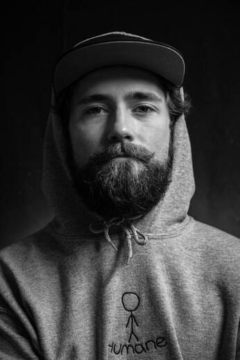 Black and white photo of young man in a hoodie staring into the camera. This illustrates the loneliness and pain of grief. Sacred Circle Holistic Healing offers grief and bereavement counseling in Lawrence and Kansas City, KS.