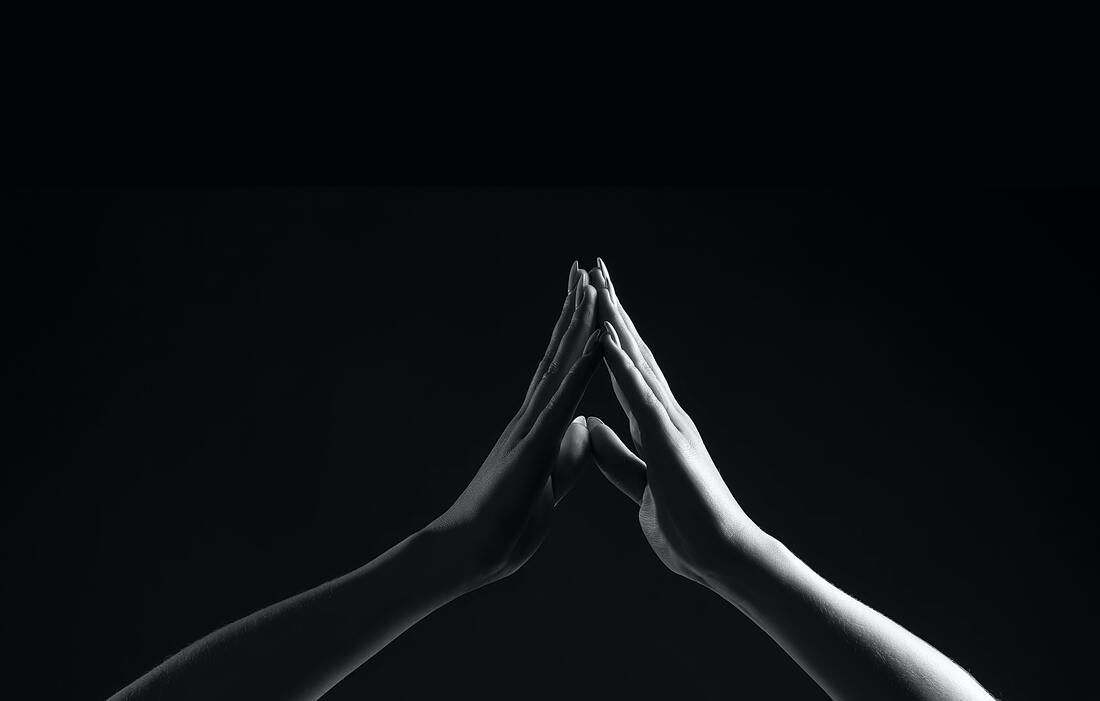 Black and white photo of two hands, fingertips touching. This illustrates how being separated from our loved ones who have died hurts, and how we want to hold on. Maggie Jones Boyle is a grief counselor in Lawrence, Kansas.