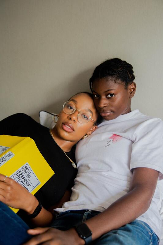Picture of a nonbinary, queer black couple lying on a bed. This illustrates that Sacred Circle Holistic Healing offers online counseling services for young adults in Kansas struggling with relational trauma, codependency, toxic relationships, and narcissistic abuse recovery.