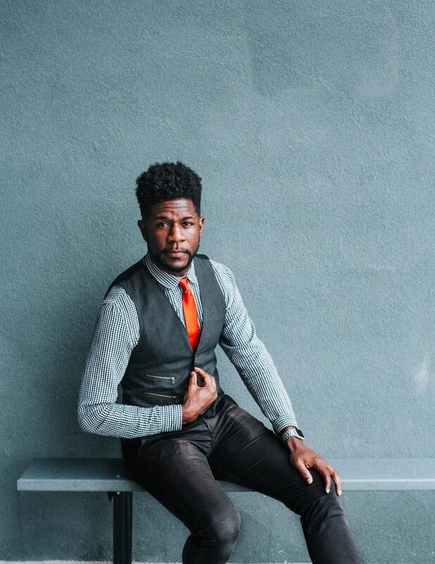 Portrait of a Black man in a vest and pinstriped shirt. This illustrates that High Sensitivity if seen equally across genders. Maggie Jones Boyle, LPC offers therapy for Highly Sensitive adults in Kansas struggling with anxiety, low self-esteem, and codependency.