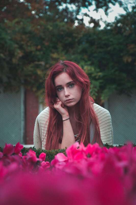 Young woman with long red hair. This illustrates that childhood trauma impact us into adulthood. Sacred Circle Holistic Healing offers online therapy in Kansas for childhood trauma.